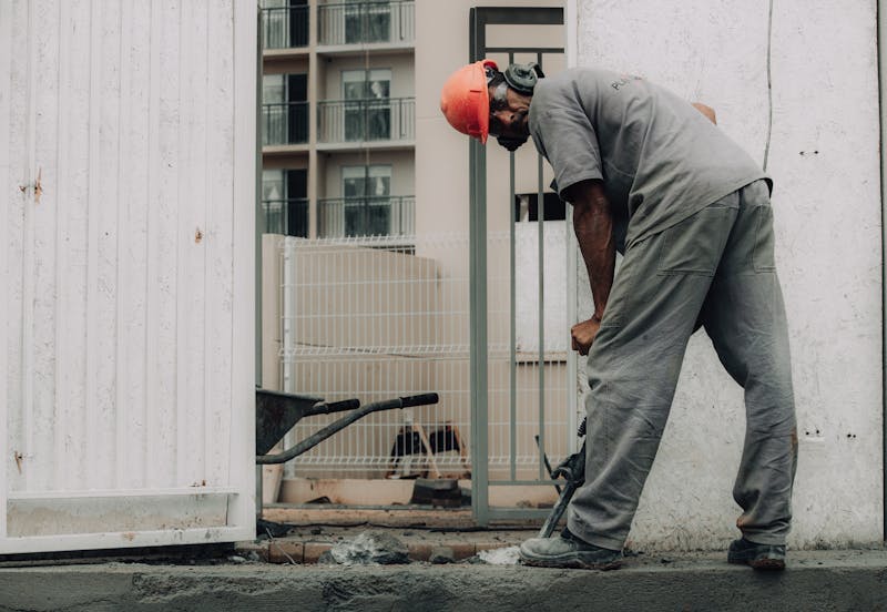 Kırıcı ile zeminde beton kırımı yapan işçi